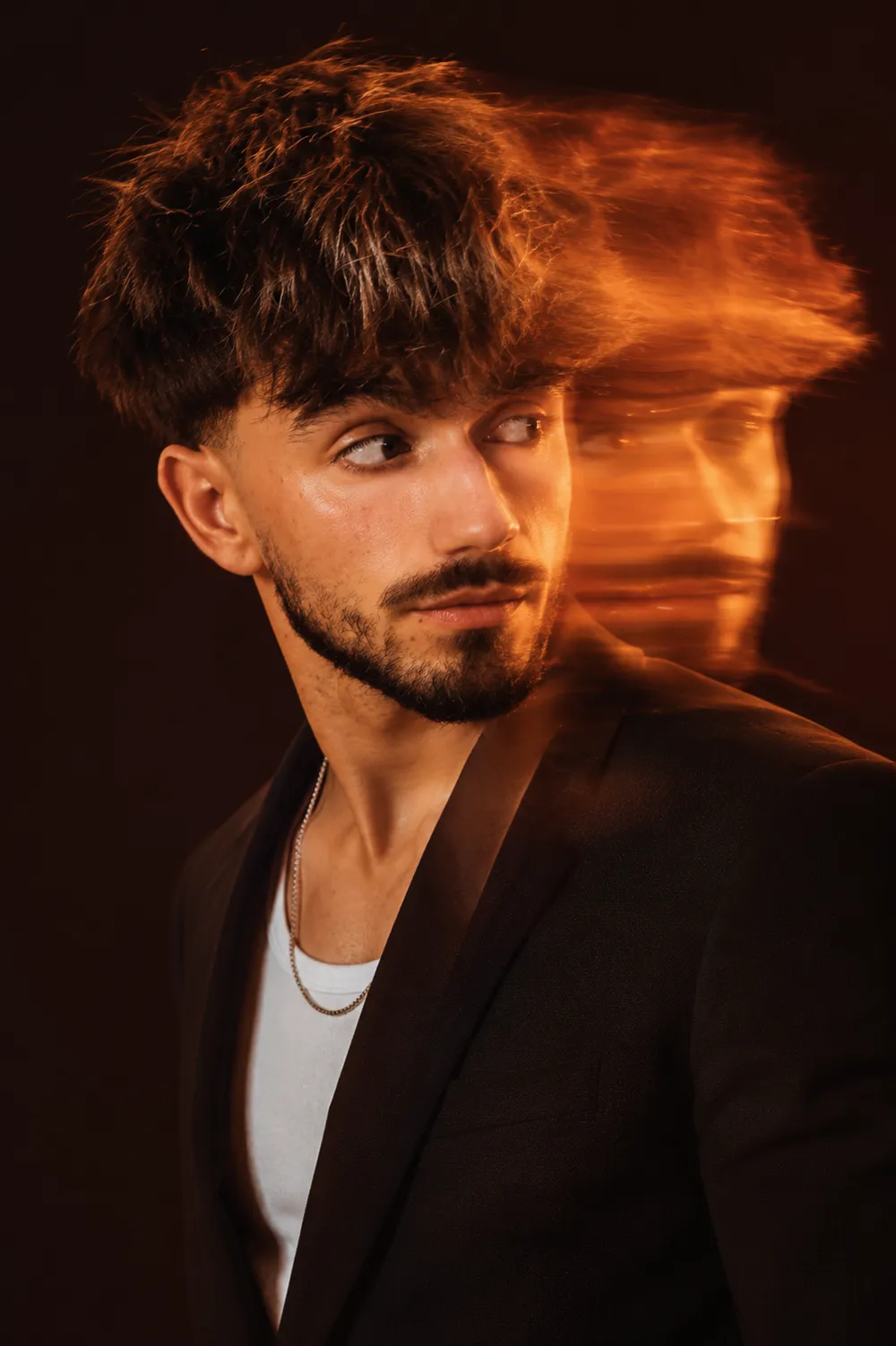 Portrait créatif du fondateur de Zooko Studio, veste orange et lunettes teintées